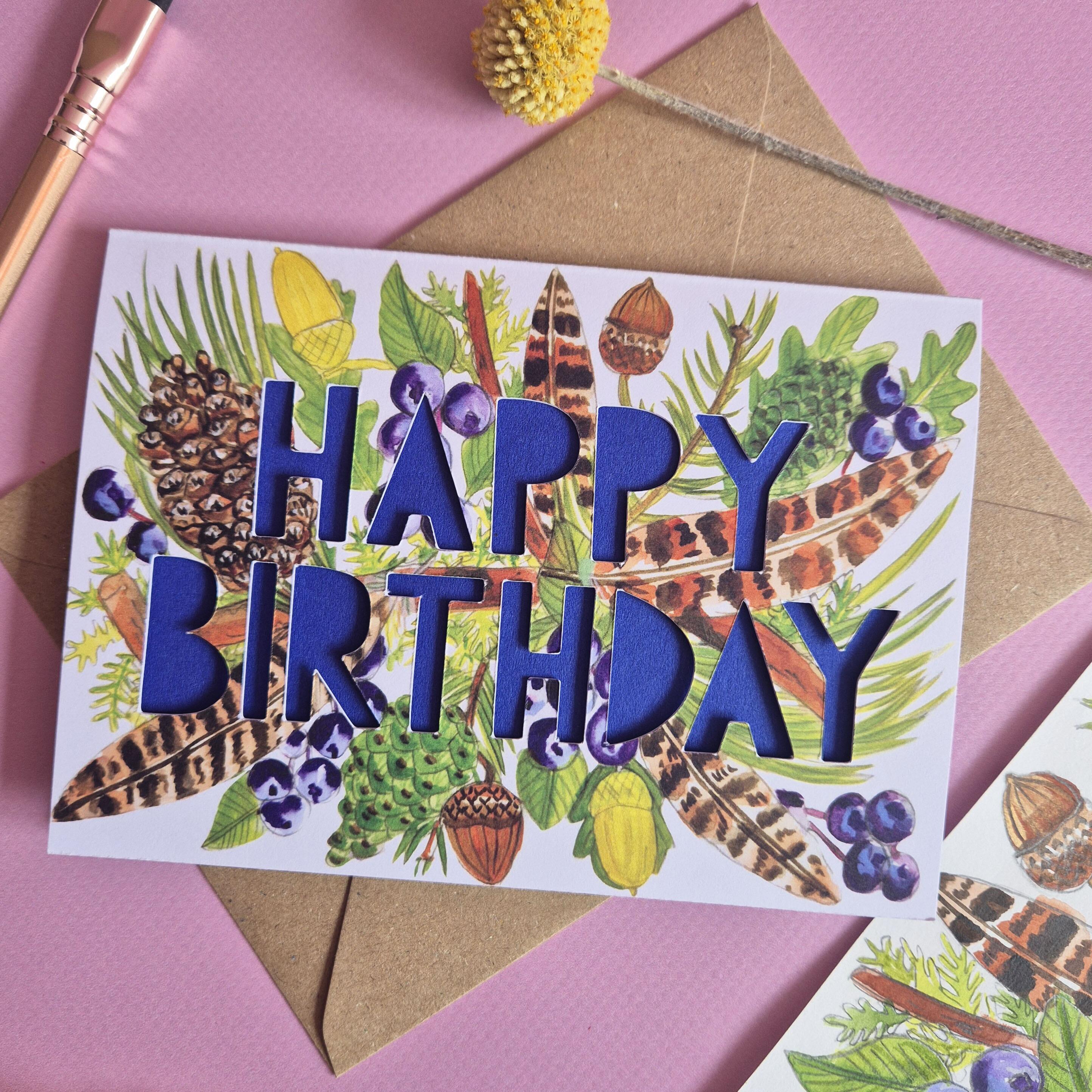feather pinecone birthday card with dark blue cobalt paper cut text close up flat