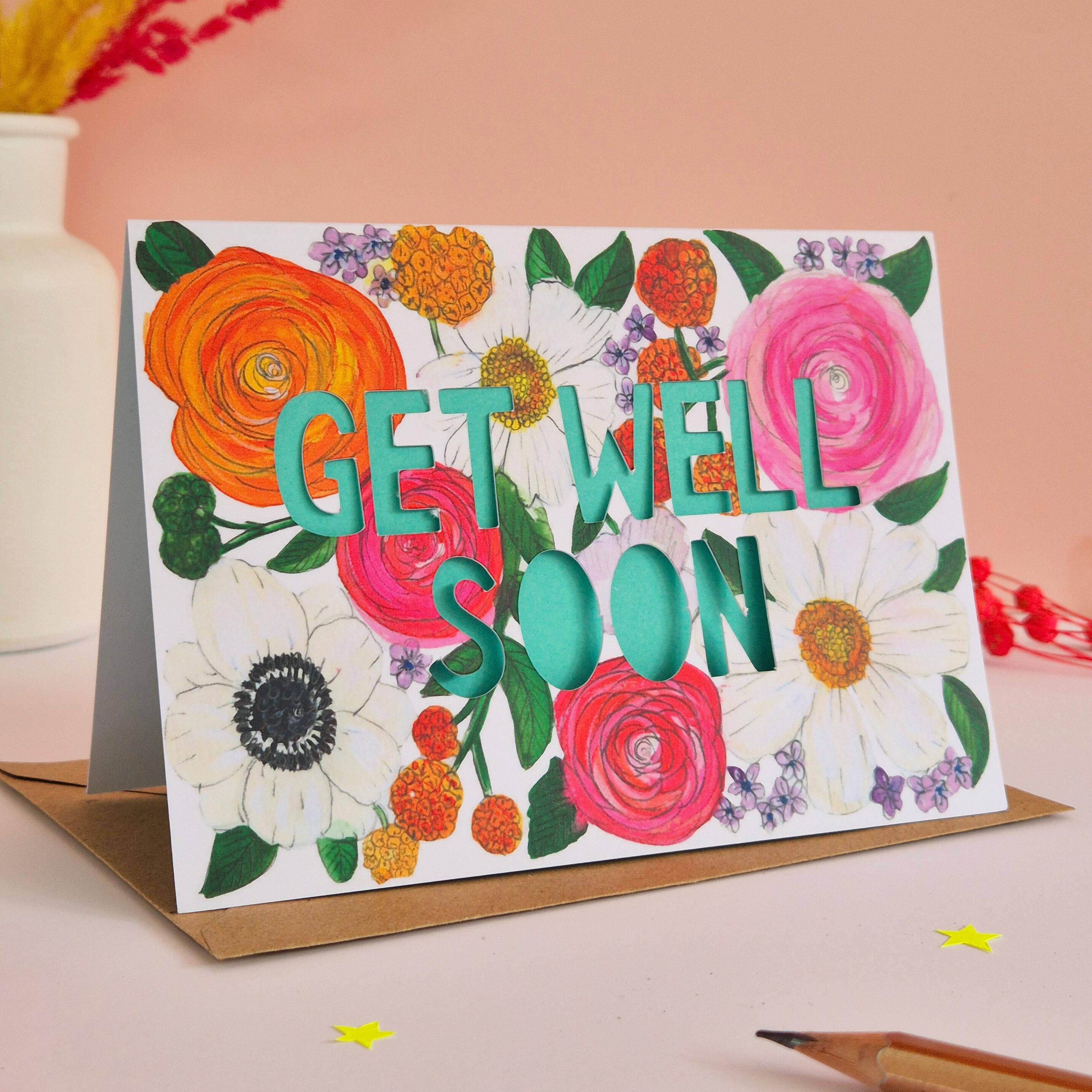 Get Well Soon card with bright floral illustration and paper cut text with bright turquoise backing paper
