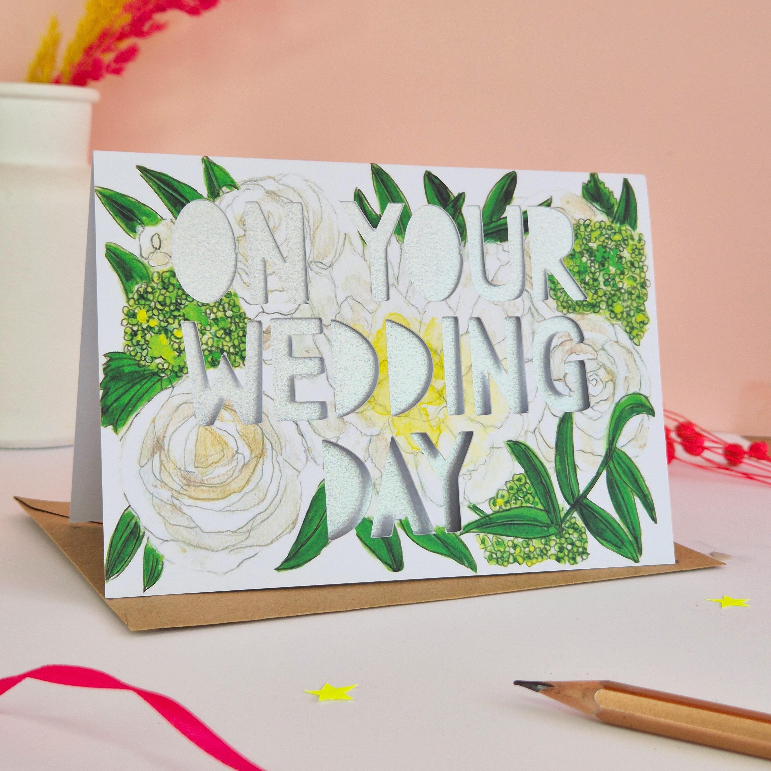 White and green floral illustration card with On Your Wedding Day die cut text and shimmering silver backing paper liner