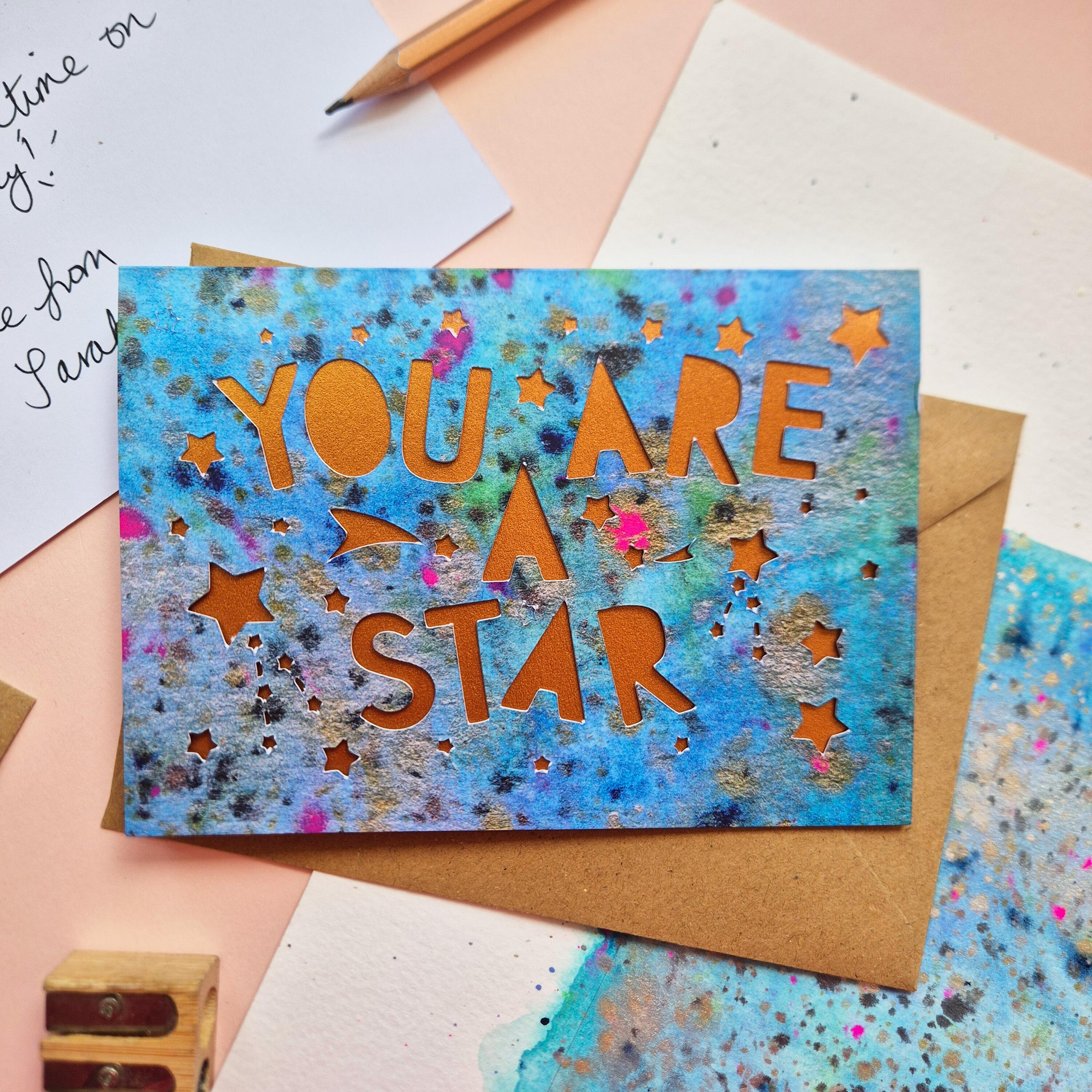 Celestial Thank You card with die cut 'You are a star' text and stars, backed with a shimmering bronze liner