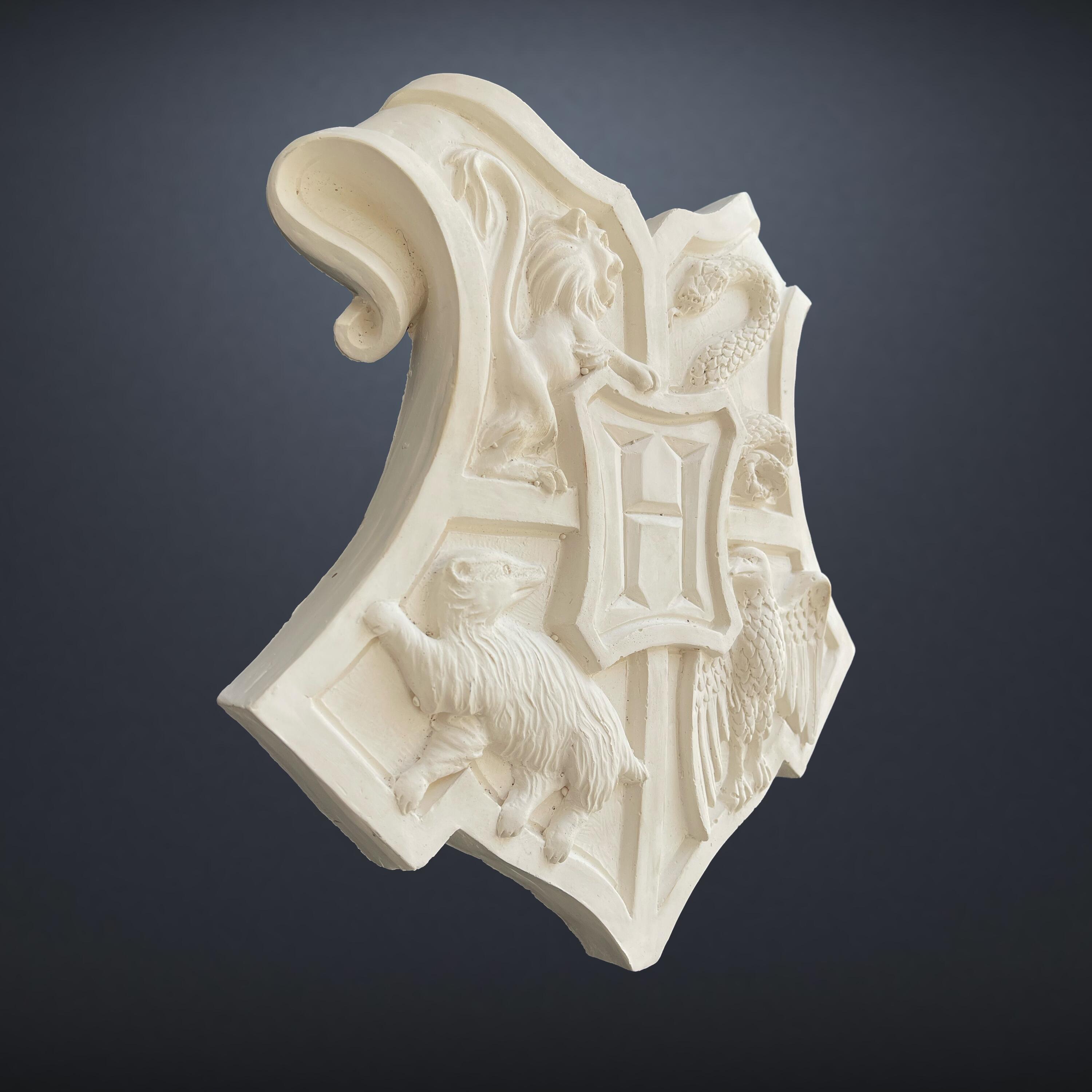 Original production-made Hogwarts Crest prop from Harry Potter and the Philosopher's / Sorcerer's Stone (2001), unpainted resin-moulded plaster coat of arms with Certificate of Authenticity. Side Angle.