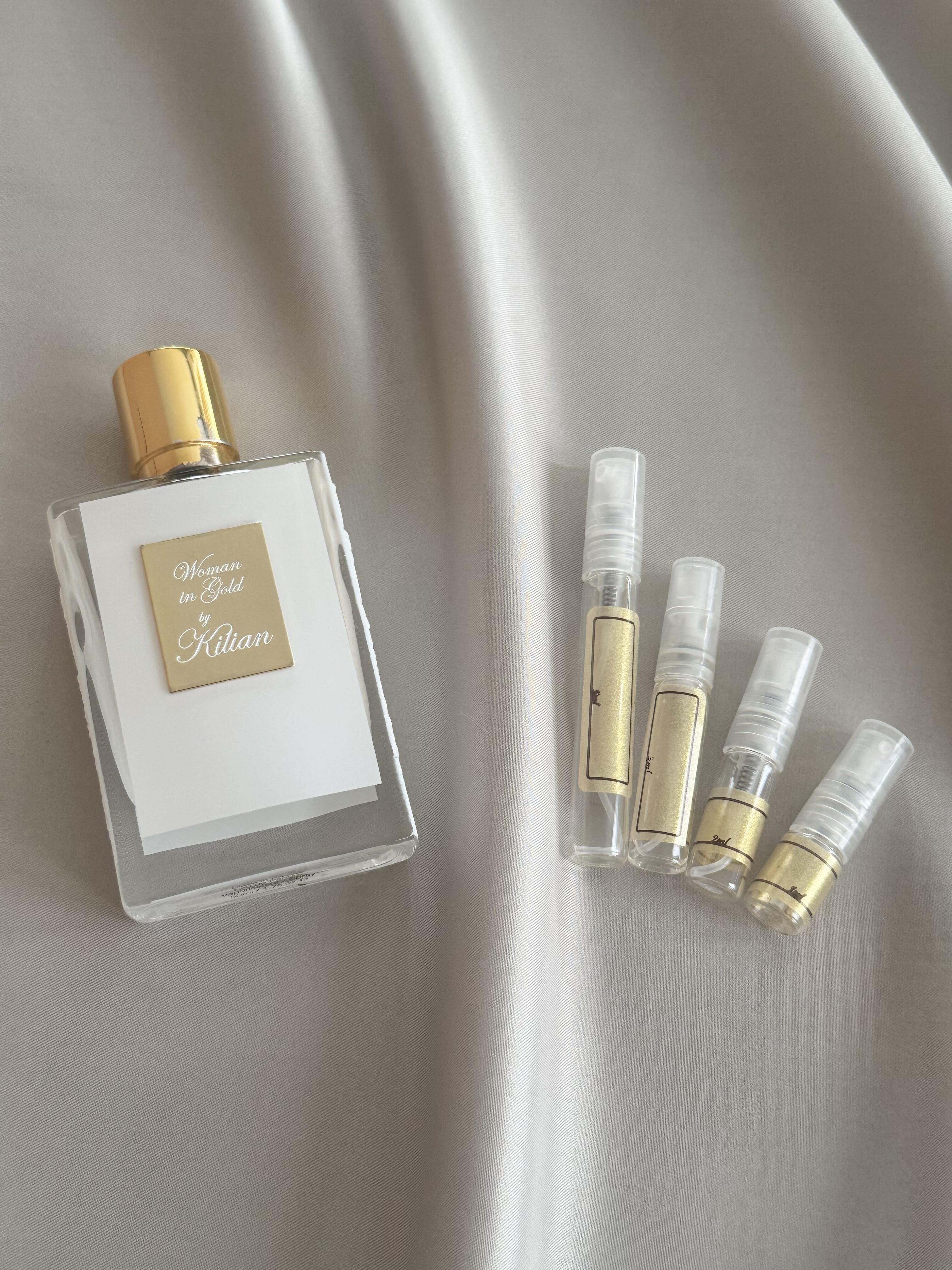 Kilian woman in Gold with sample bottles