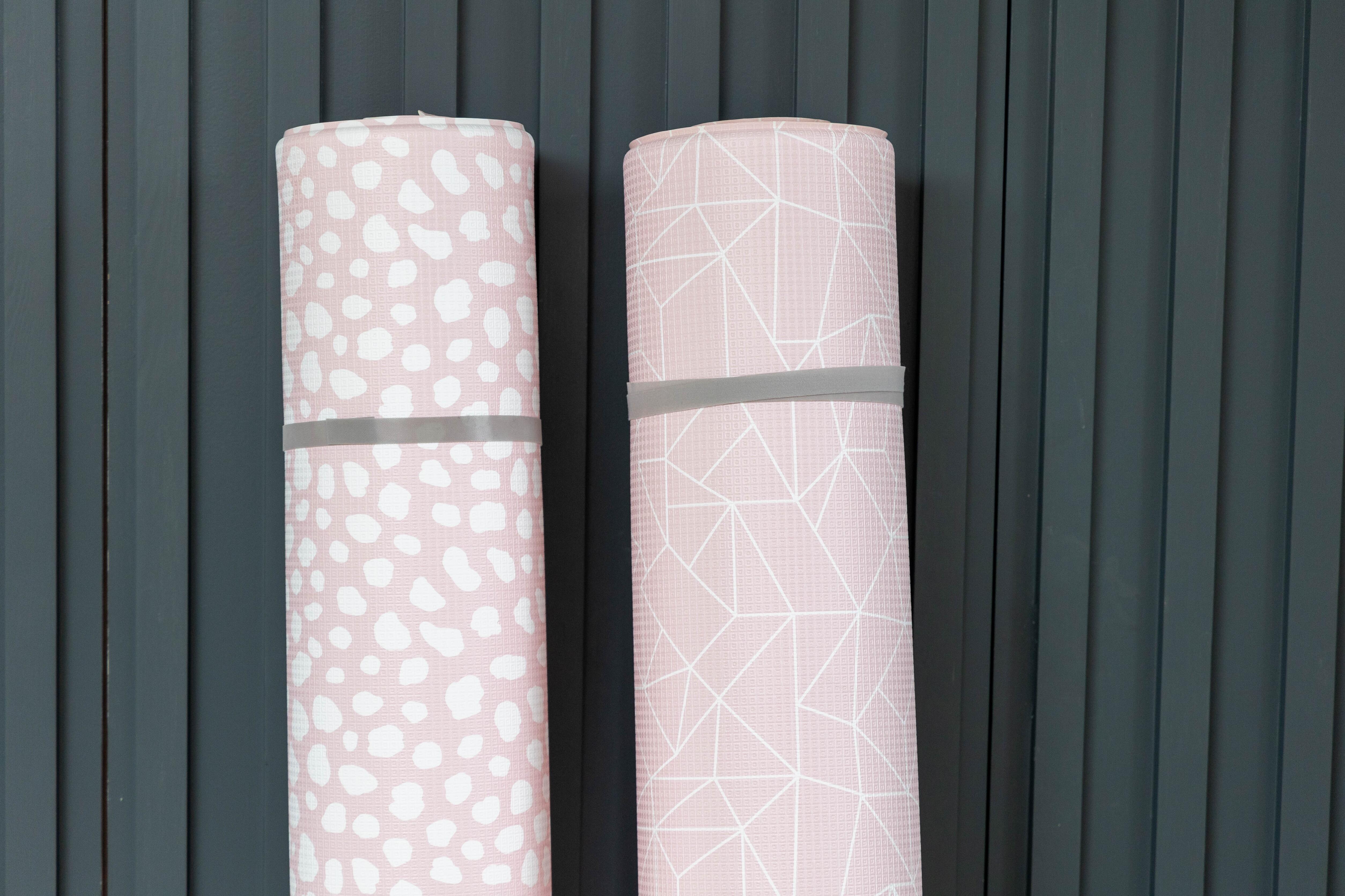 Large Darling Dalmatian and Nordic Explorer Blush Pink reversible playmats rolled up together – non-toxic cushioned foam baby mats by Little Fae