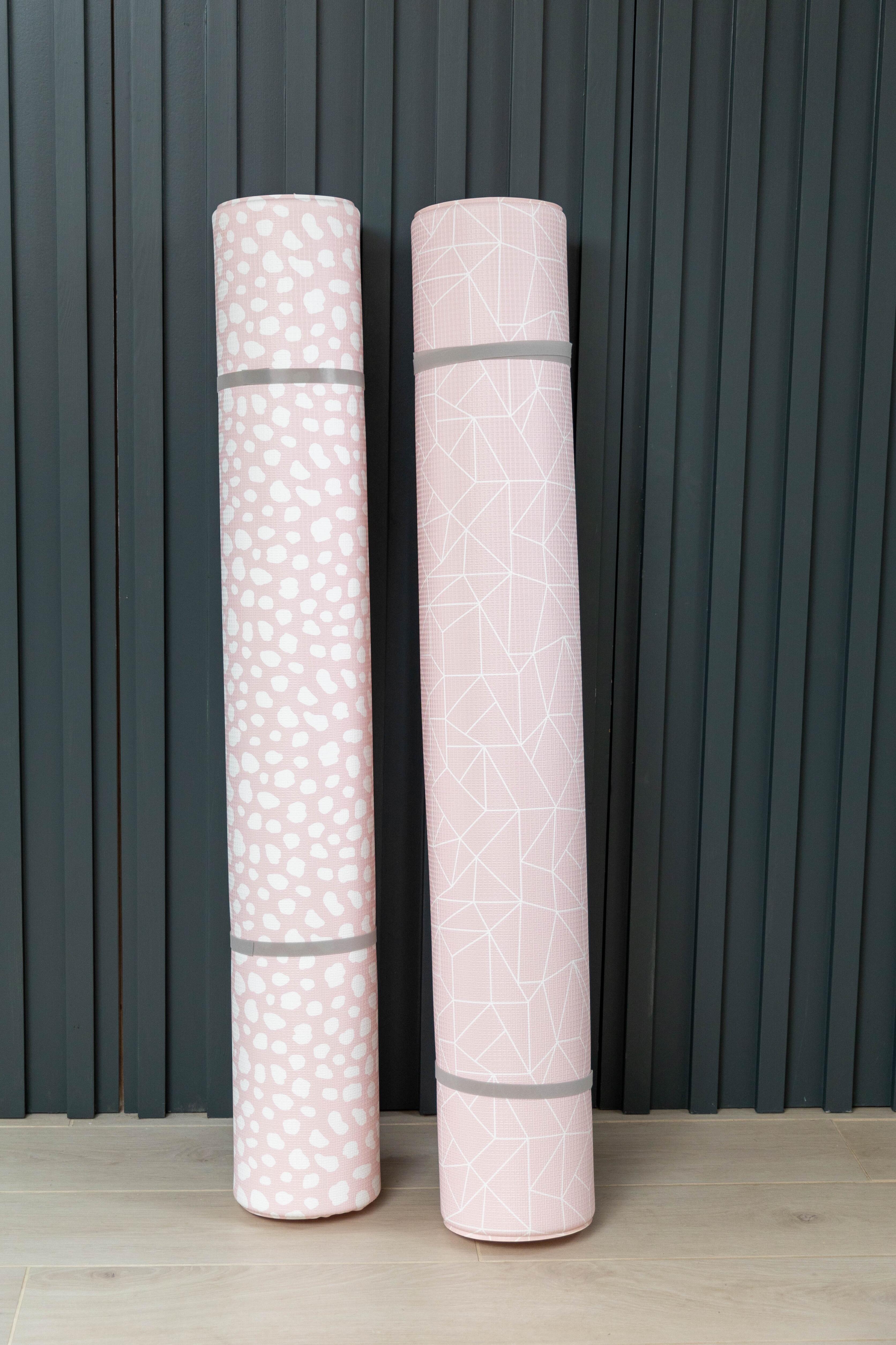 Both sides of the Blush Pink reversible playmat shown rolled together – Darling Dalmatian and Nordic Explorer designs in soft neutral tones by Little Fae