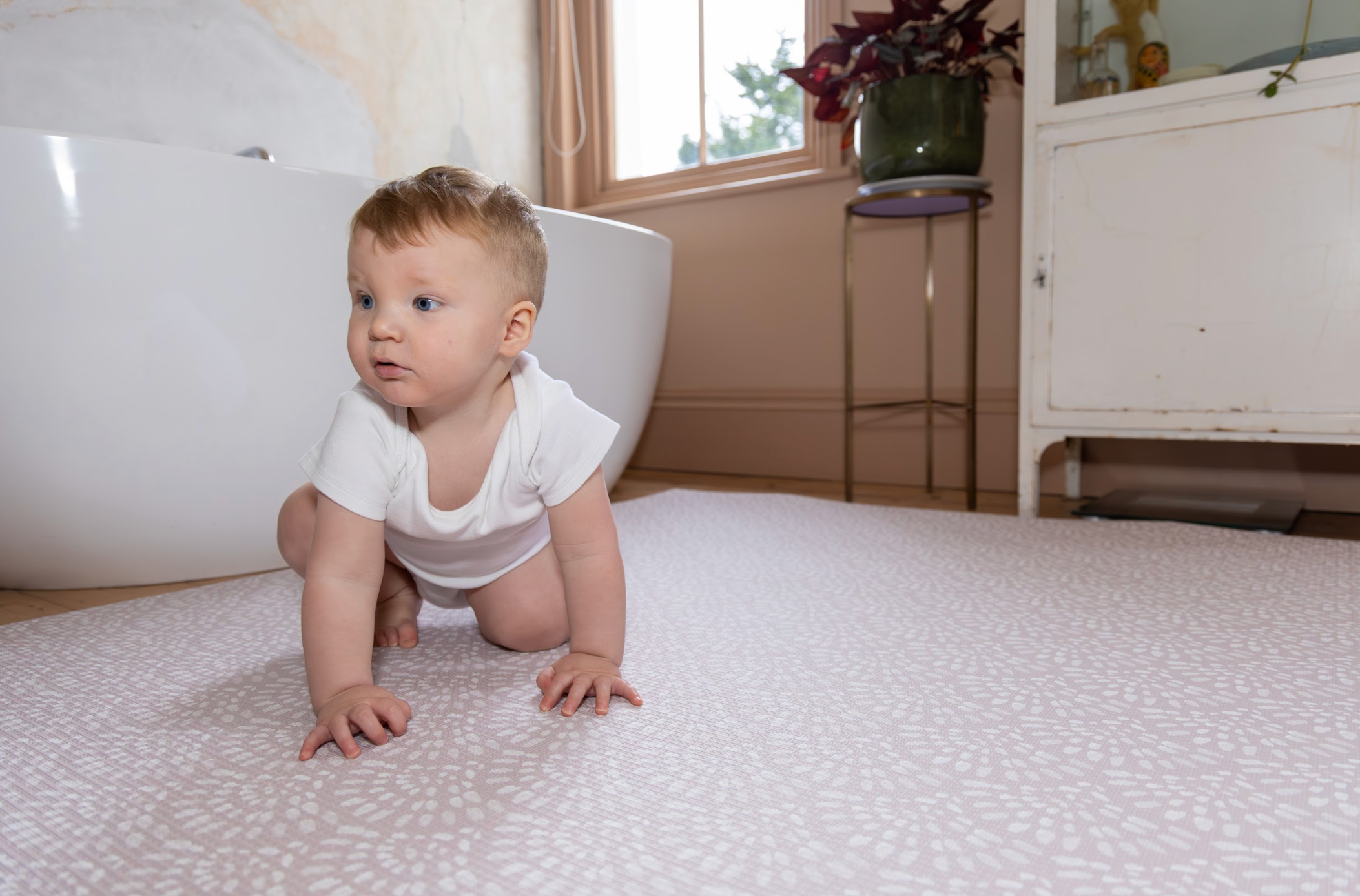 Baby playing on Scandi Pink reversible playmat – soft wipe-clean non-toxic finish by Little Fae