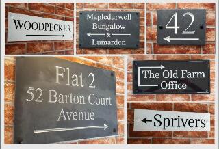 Display of house signs with directional arrows in different styles and sizes