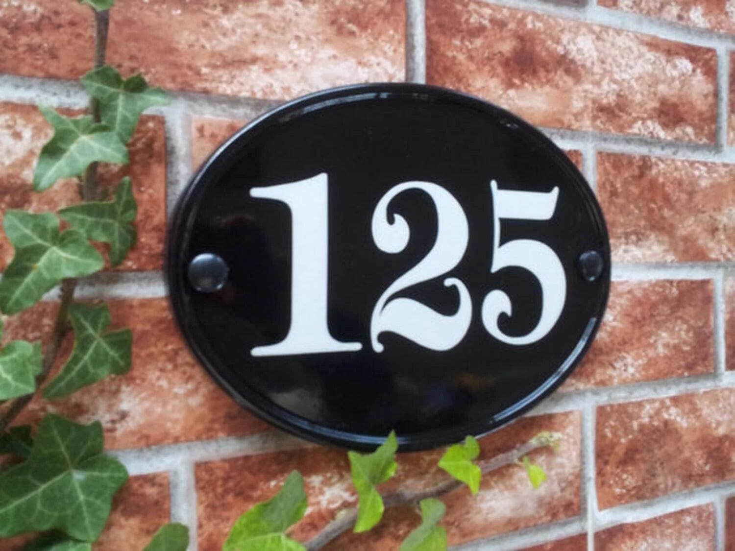 Black oval house number sign displaying 125