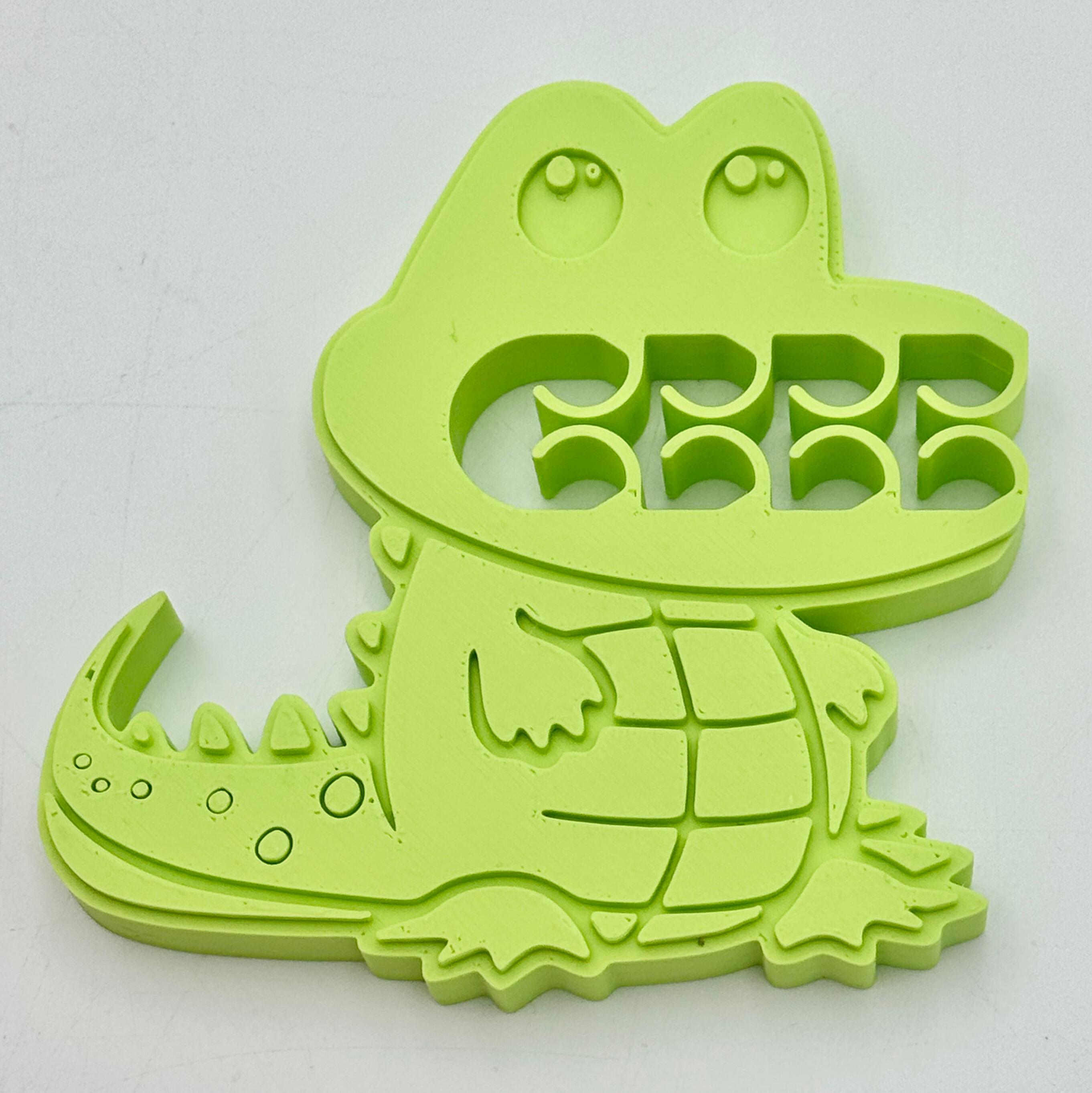 A light green crocodile bag clip