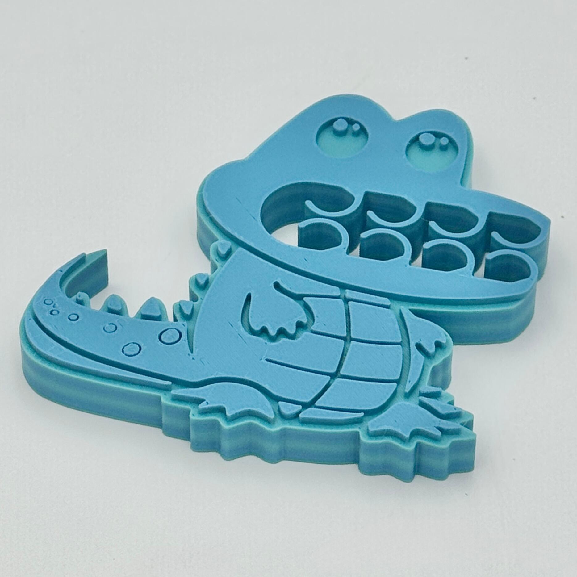 A crocodile bag clip in shades of blue