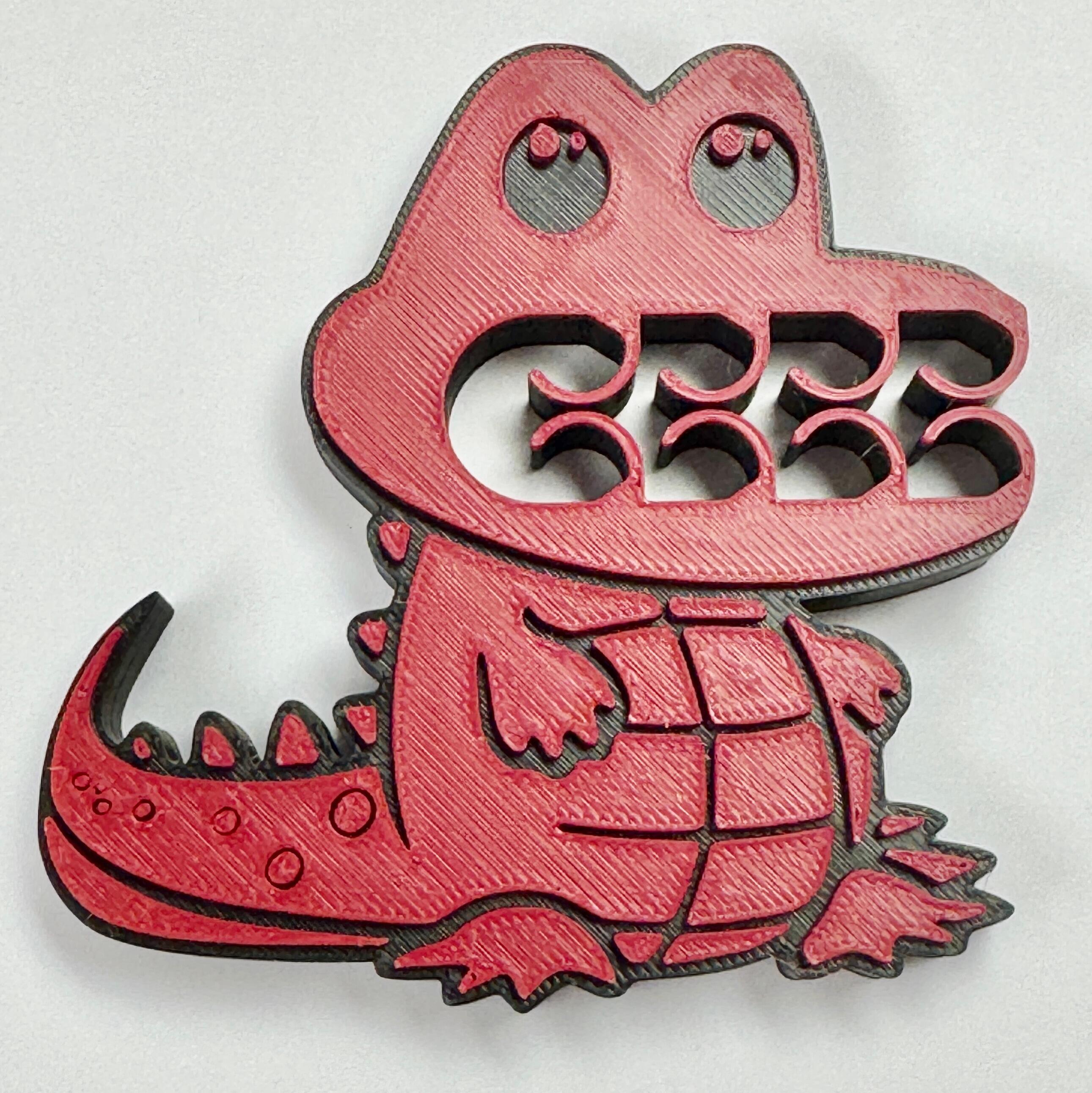 A red and black crocodile bag clip