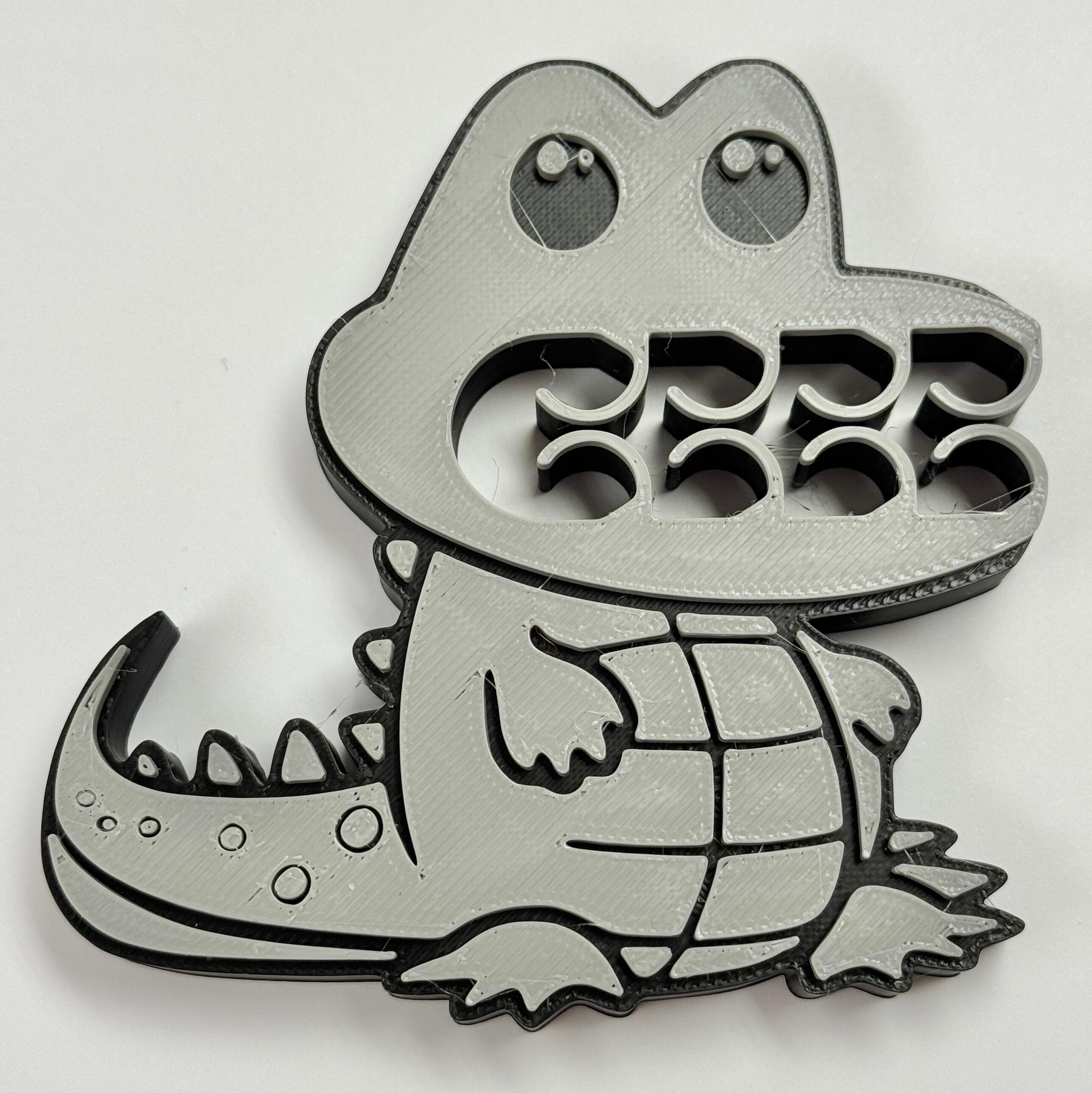 A grey and black crocodile bag clip