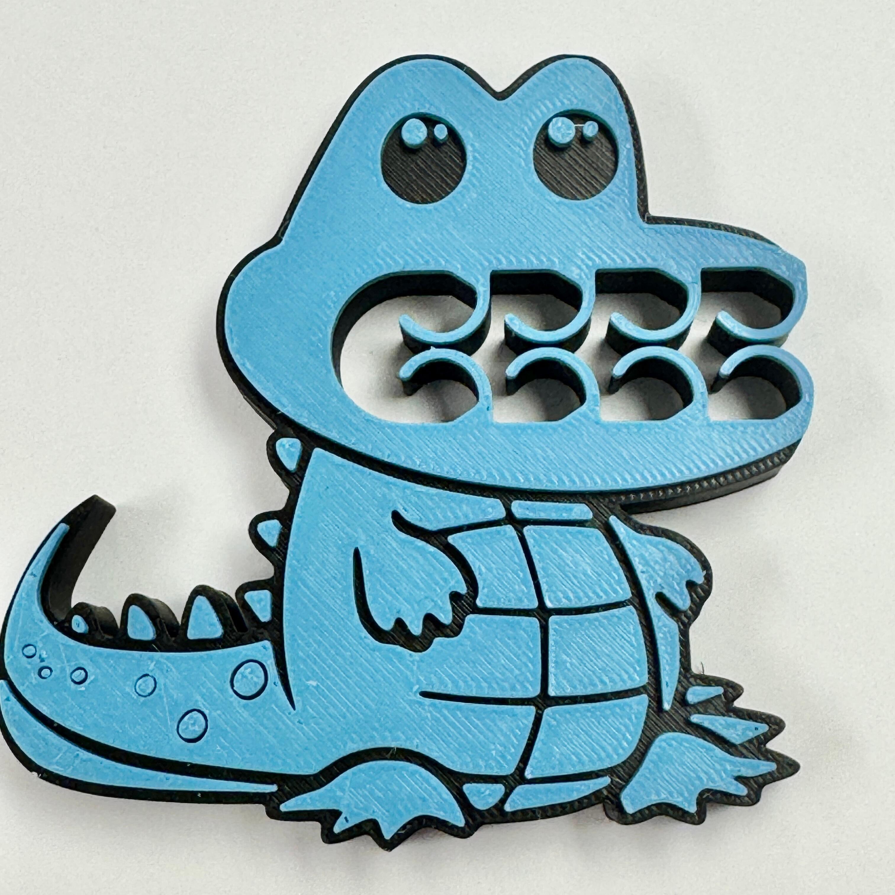 A blue and black crocodile bag clip