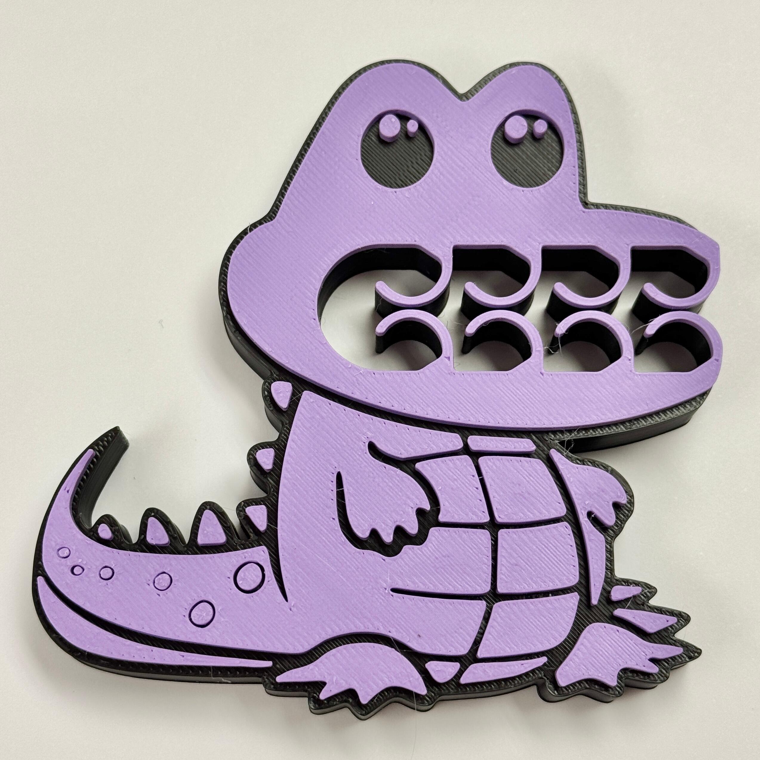 A purple and black crocodile bag clip