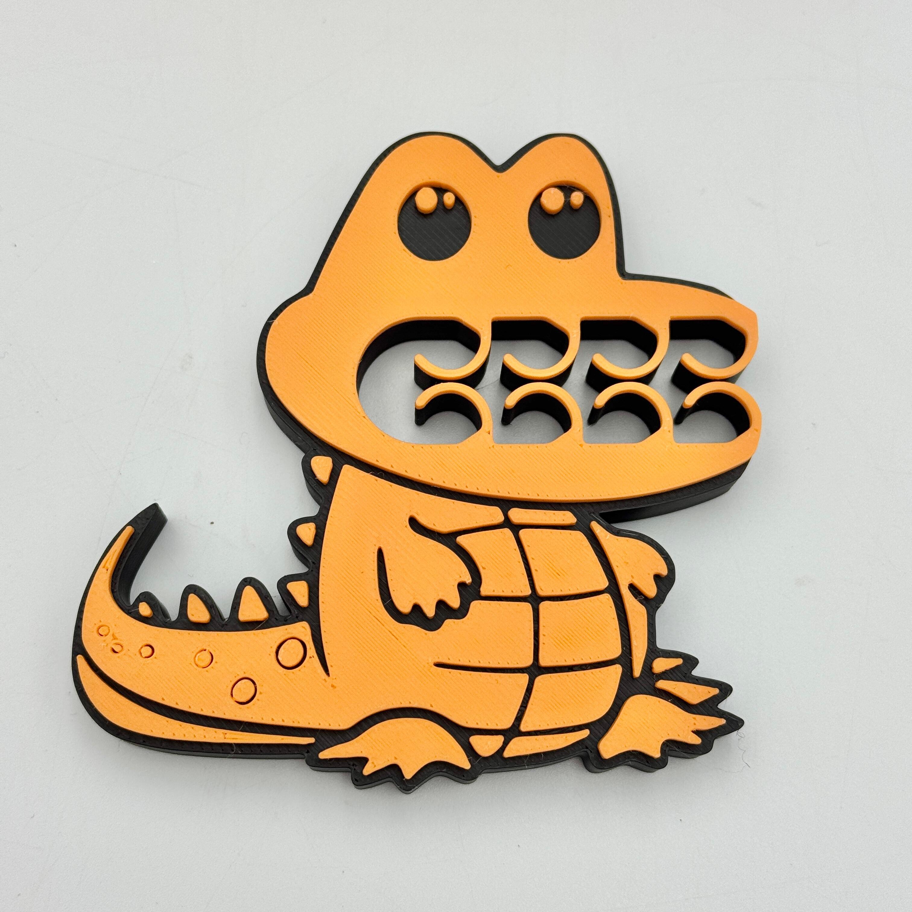 A orange and black crocodile bag clip