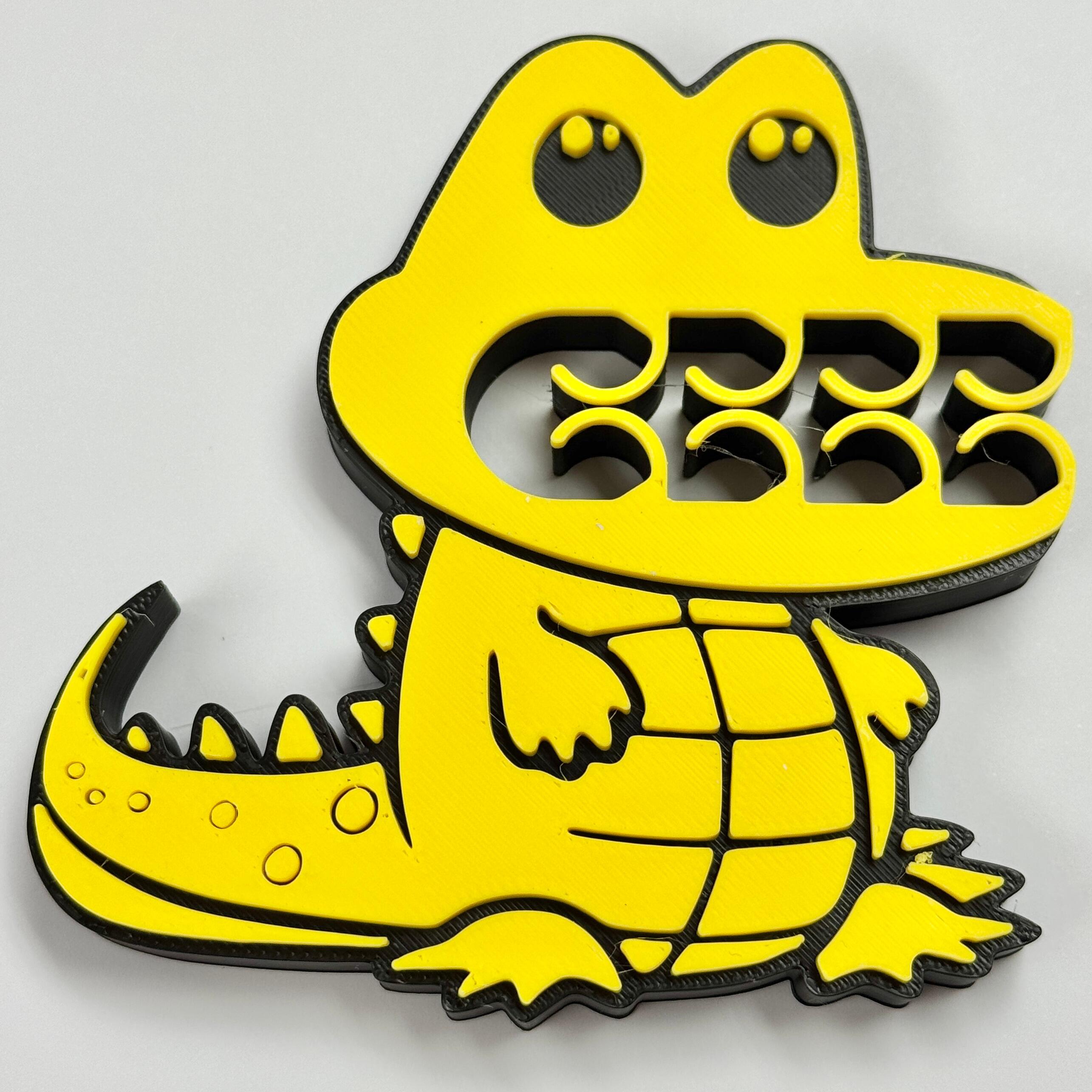 A yellow and black crocodile bag clip