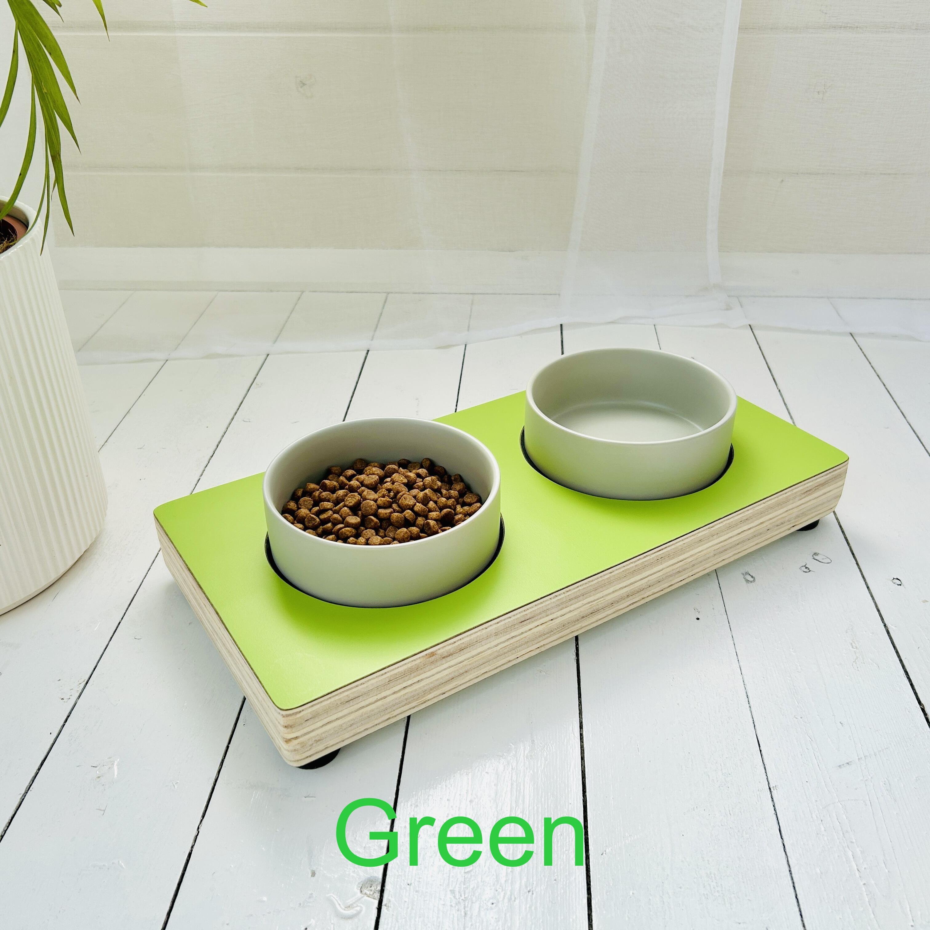 bright green topped low wooden pet feeder with two grey ceramic bowls on top