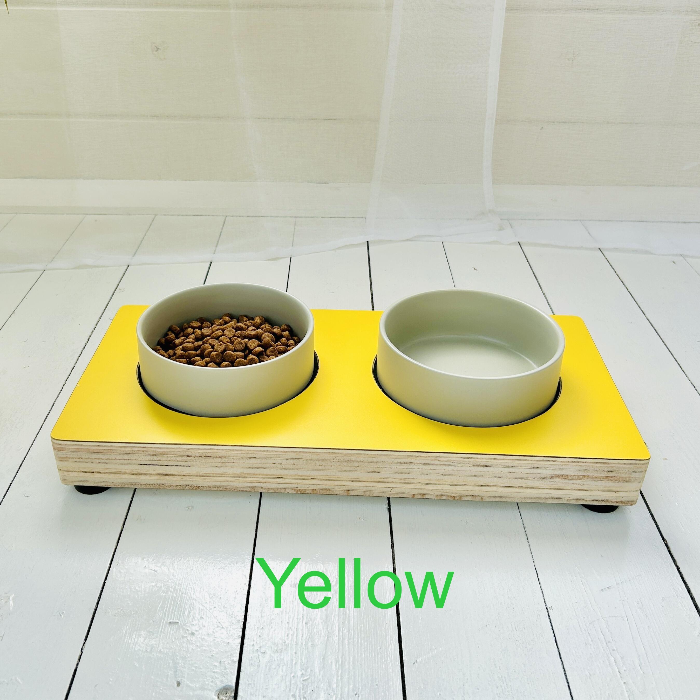 bright yellow topped wooden puppy feeding shelf on painted white summer room background