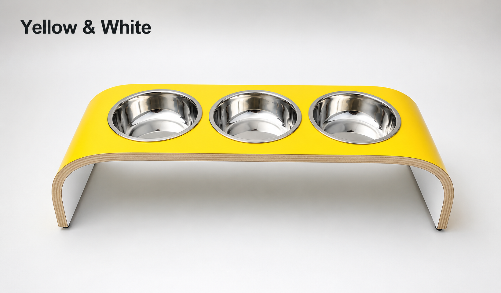 Modern yellow and white raised triple dog bowl stand with stainless steel bowls, handcrafted curved wooden pet feeder for dogs and cats.