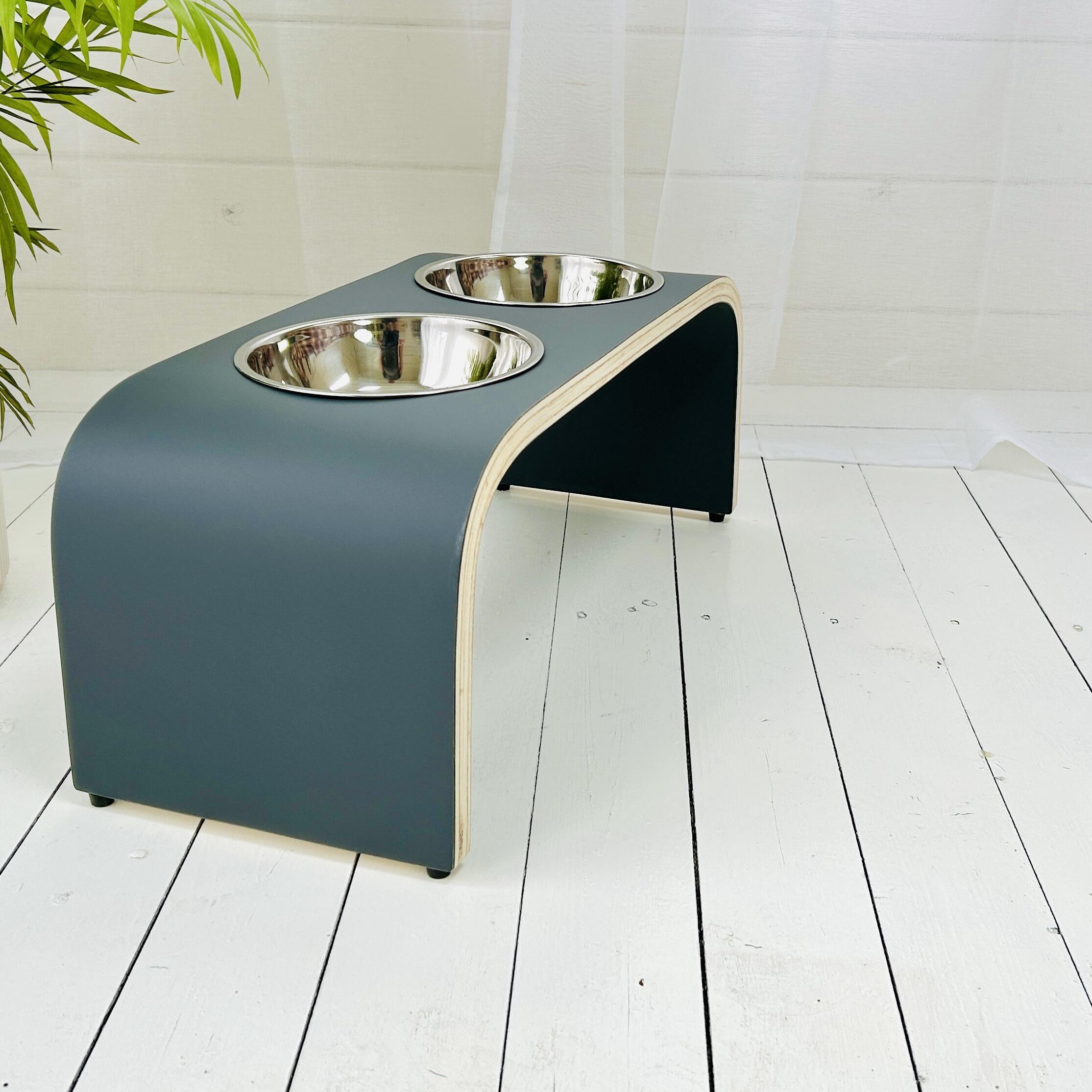 matt dark grey finished wooden dog bowl holder with two stainless steel bowls at an angle on wooden floor