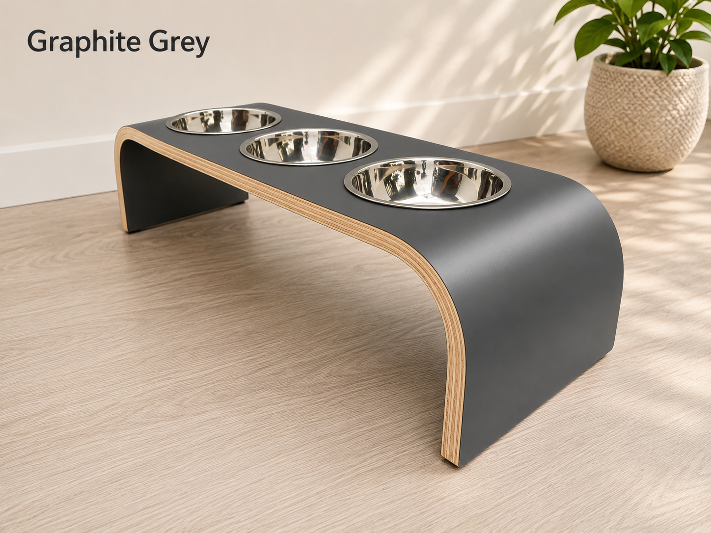 Modern graphite grey raised triple dog bowl stand with stainless steel bowls, handcrafted curved wooden pet feeder for dogs and cats.