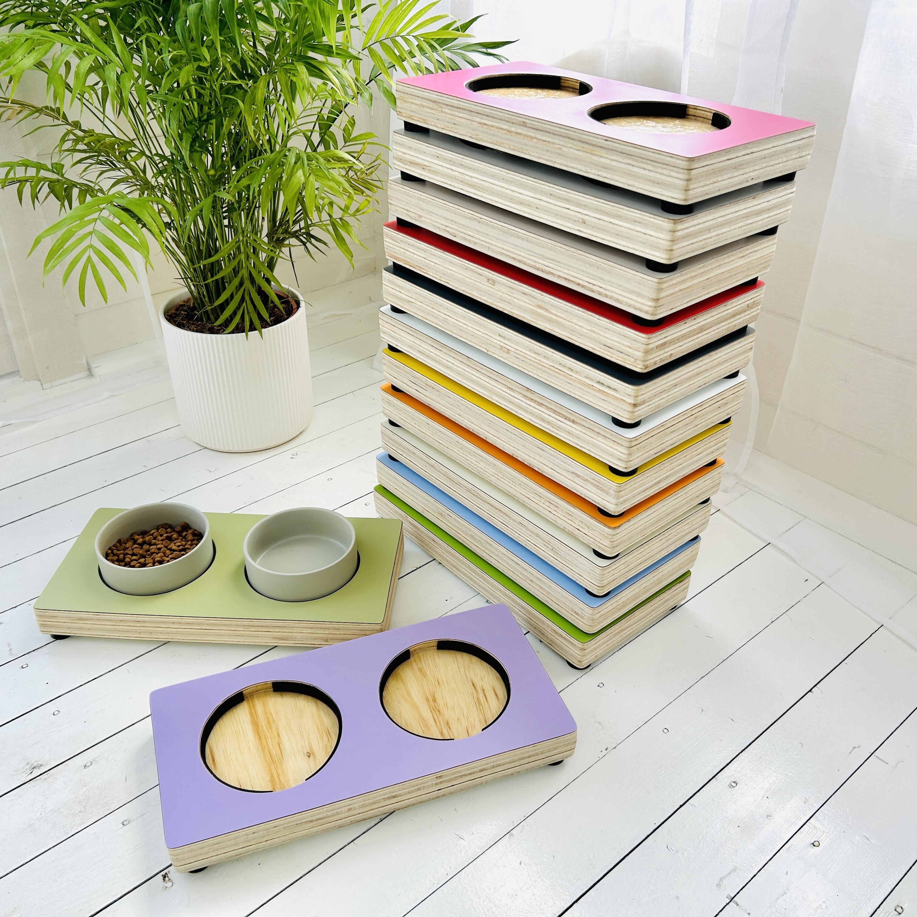a tower of brightly coloured solid wood cat feedign stands with ceramic bowls in white garden room