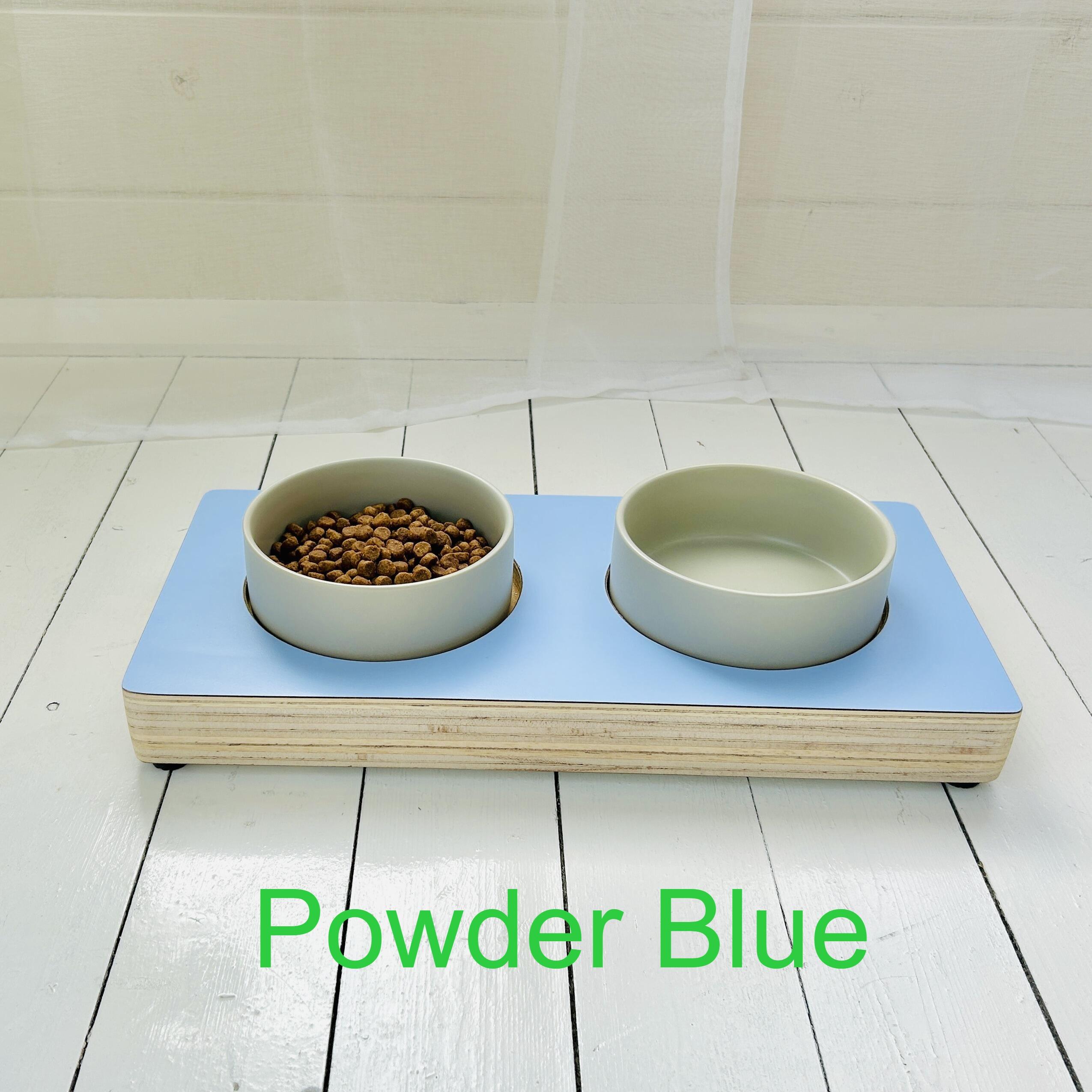 light blue cool finish wooden puppy stand with grey ceramic bowls in bright white garden room