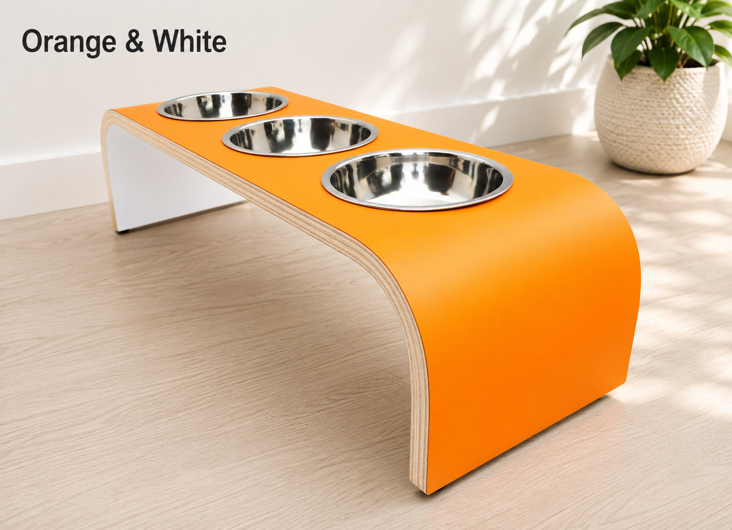 Modern orange and white raised triple dog bowl stand with stainless steel bowls, handcrafted curved wooden pet feeder for dogs and cats.