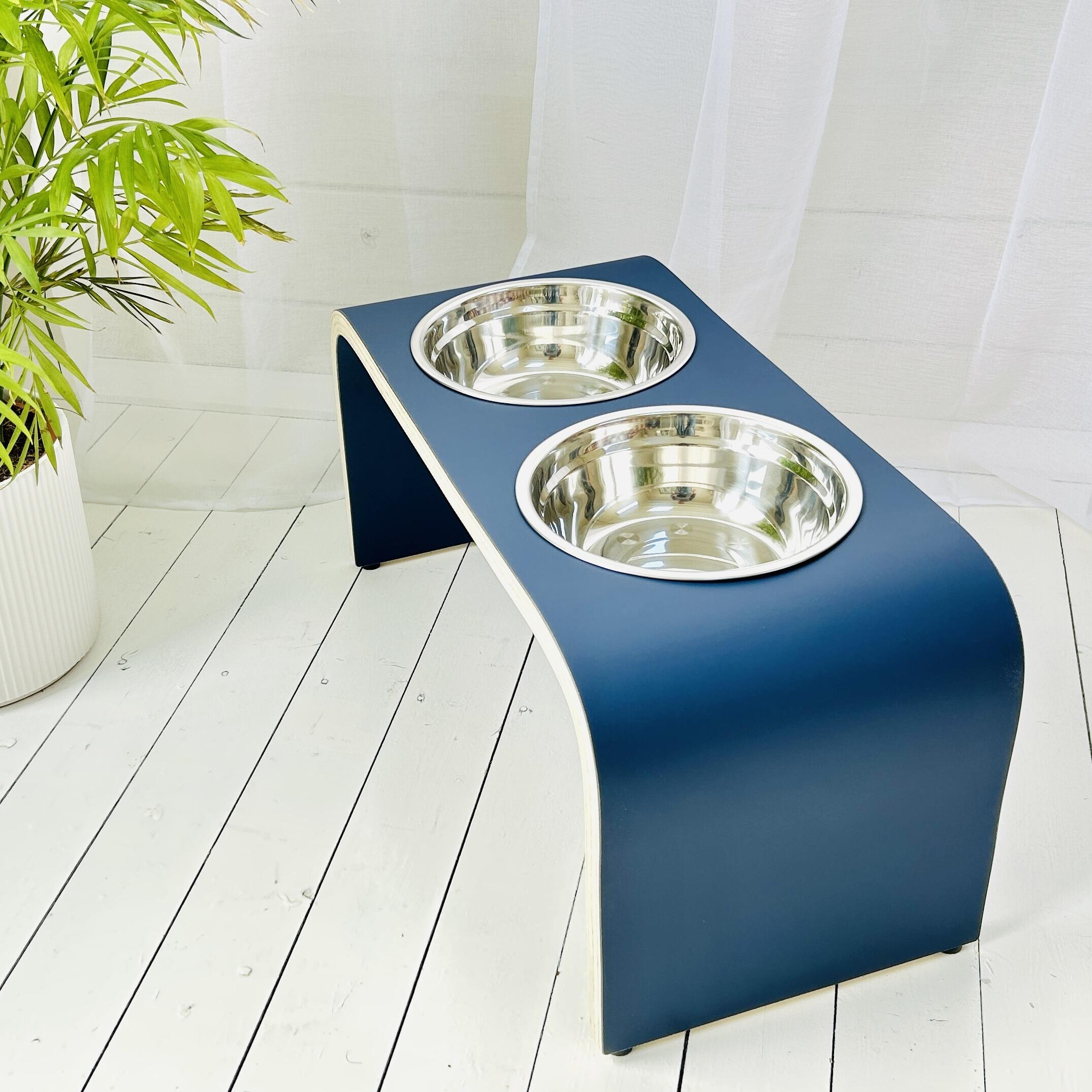 high wooden dog feeding station in matt blue colour with two dog bowls