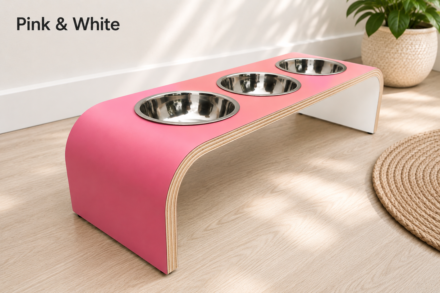 Modern pink and white raised triple dog bowl stand with stainless steel bowls, handcrafted curved wooden pet feeder for dogs and cats.