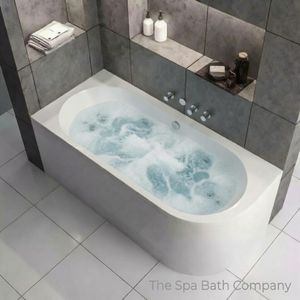 A left handed J shape whirlpool bath fitted in a modern bathroom with grey tiles