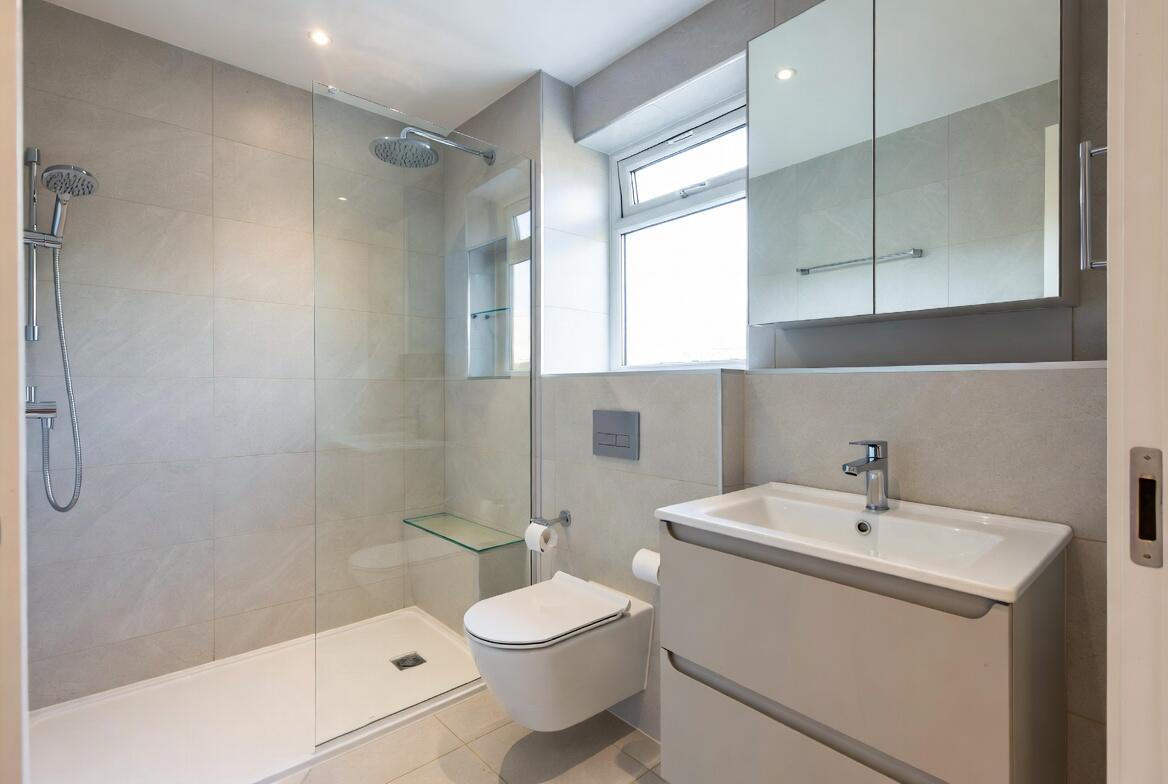 Compact modern bathroom with walk-in shower, wall-hung fixtures and smart storage