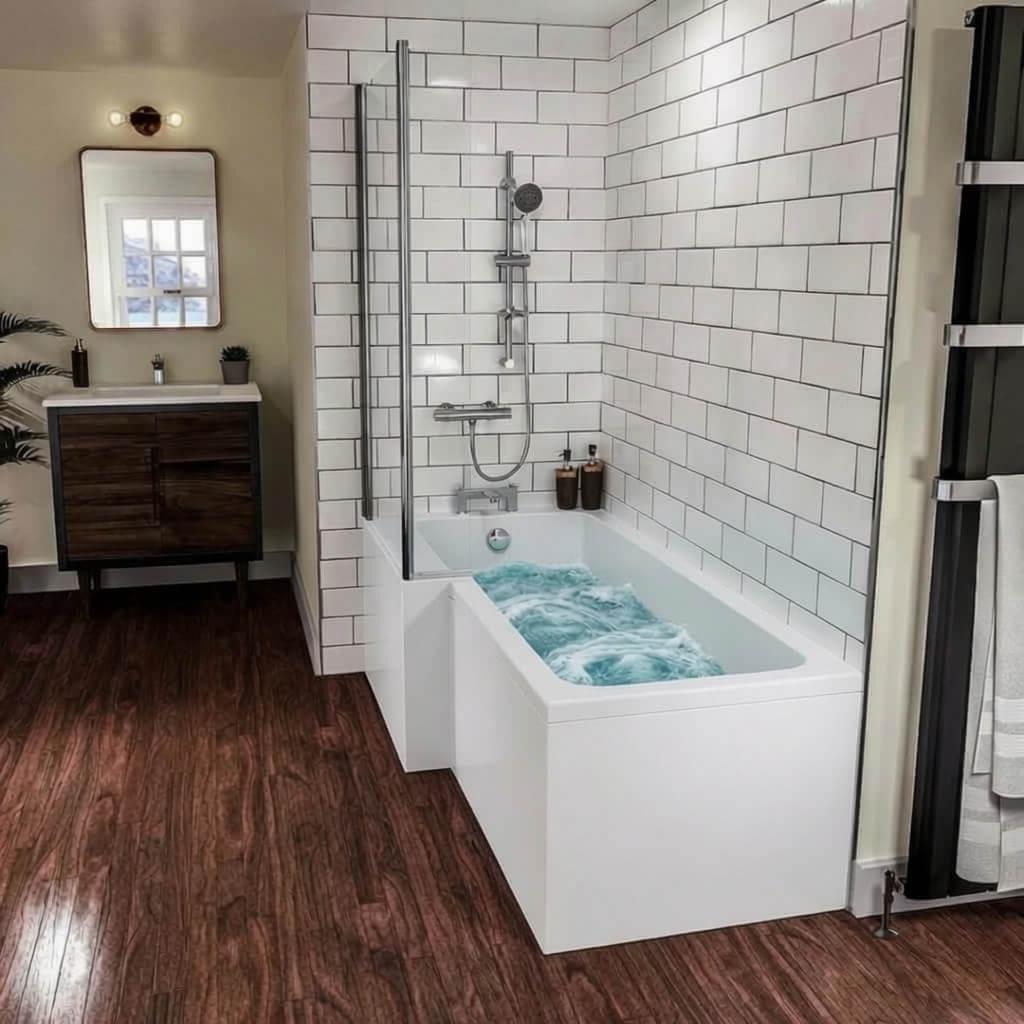 White L-shaped bath with bubbly light blue water in modern bathroom with subway tiles, dark wood floor and vanity.