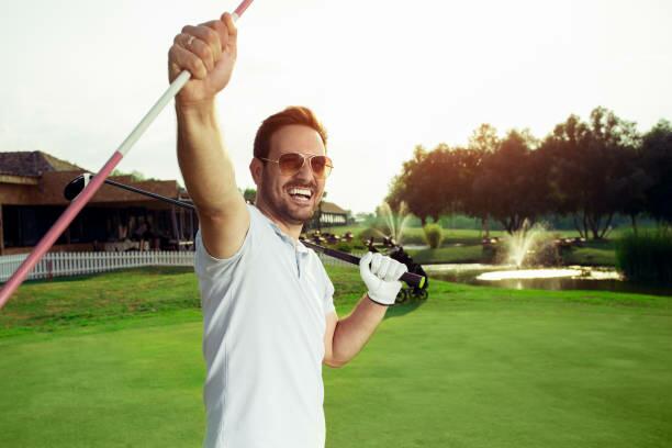 Image a golfer celebrating a putt on the green.