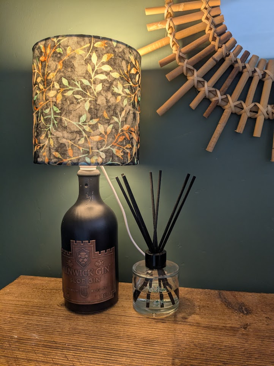 An image of a handmade lamp using a 'La Fleuriste' gin bottle, paired with a 20cm drum lampshade.