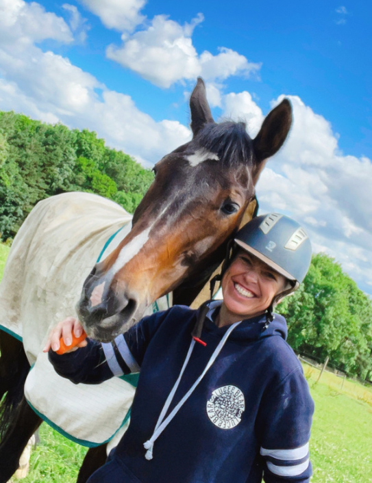 Woman with horse wearing navy Game Day Hoodie