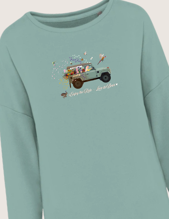 Woman wearing dusty green Enjoy the Ride sweatshirt