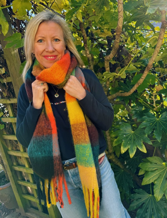 Woman wearing the Ultimate Blanket Scarf in Rainbow Brights