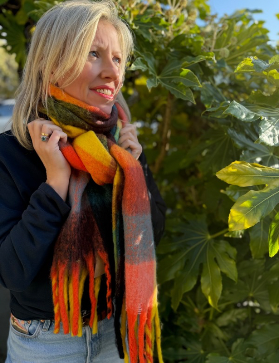 Woman wearing the Ultimate Blanket Scarf in Rainbow Brights