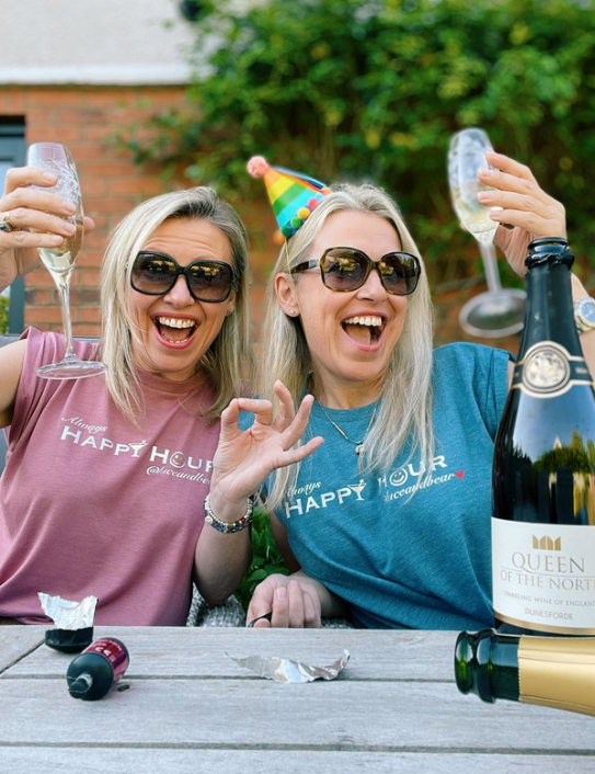 Two women wearing Happy Hour Tees