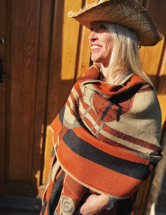 Woman wearing cashmere blend Warrior Wrap in orange