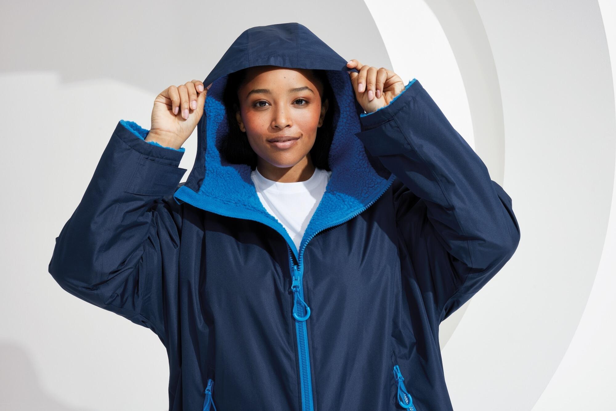All-seasons waterproof changing robe with a hood, adjustable straps, double zip closure, and multiple deep pockets, featuring a waterproof exterior and cosy sherpa fleece interior.