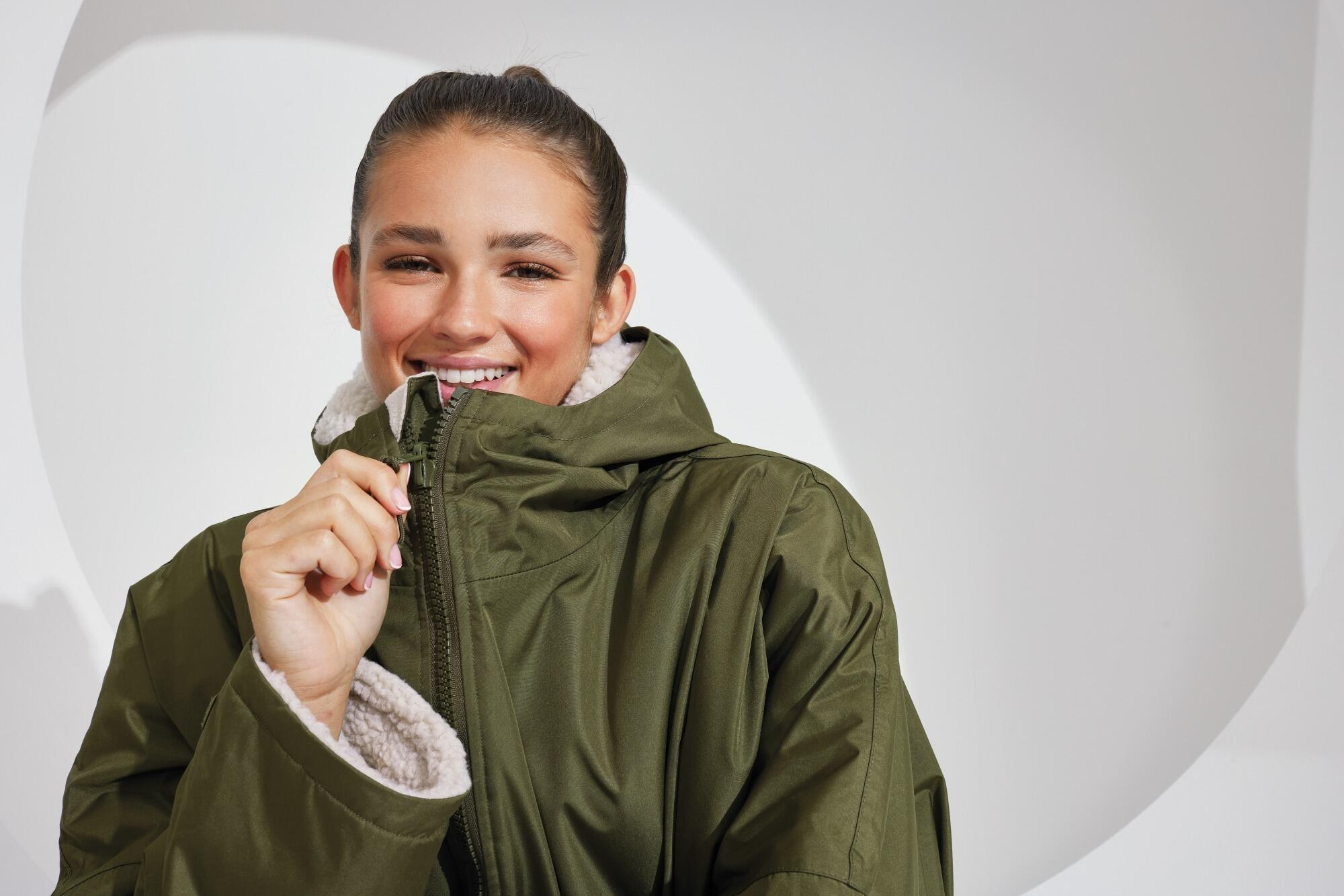 All-seasons waterproof changing robe with a hood, adjustable straps, double zip closure, and multiple deep pockets, featuring a waterproof exterior and cosy sherpa fleece interior.