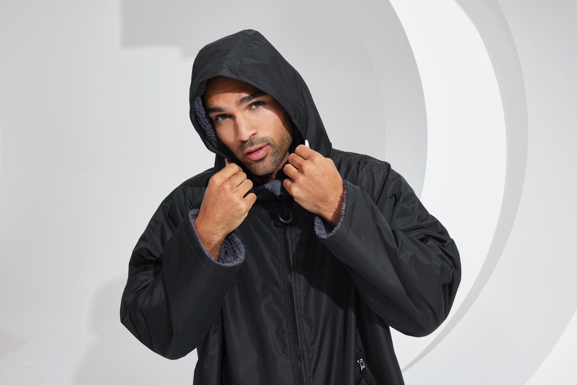 All-seasons waterproof changing robe with a hood, adjustable straps, double zip closure, and multiple deep pockets, featuring a waterproof exterior and cosy sherpa fleece interior.