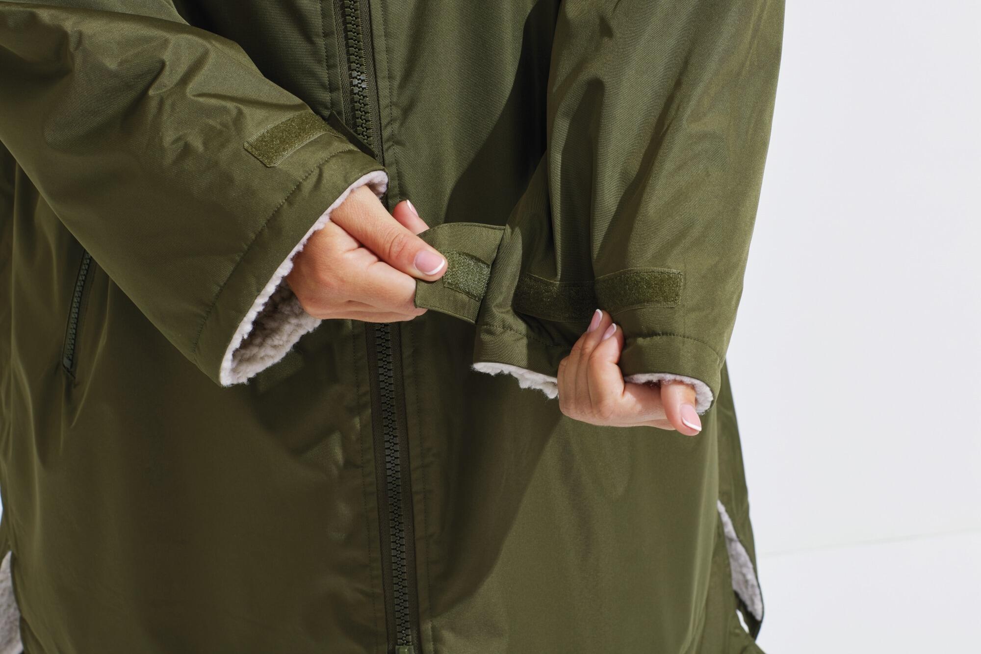 All-seasons waterproof changing robe with a hood, adjustable straps, double zip closure, and multiple deep pockets, featuring a waterproof exterior and cosy sherpa fleece interior.