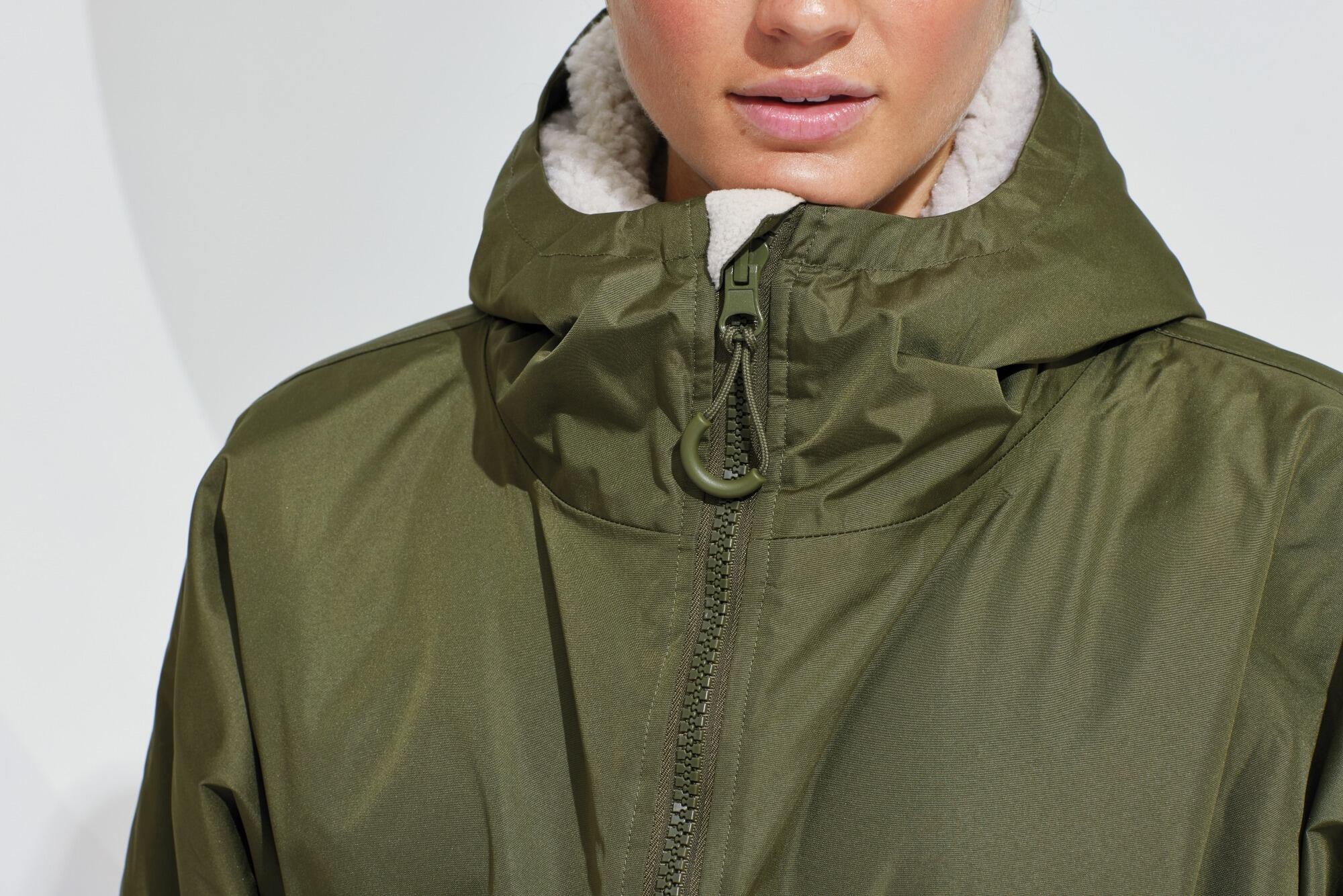 All-seasons waterproof changing robe with a hood, adjustable straps, double zip closure, and multiple deep pockets, featuring a waterproof exterior and cosy sherpa fleece interior.
