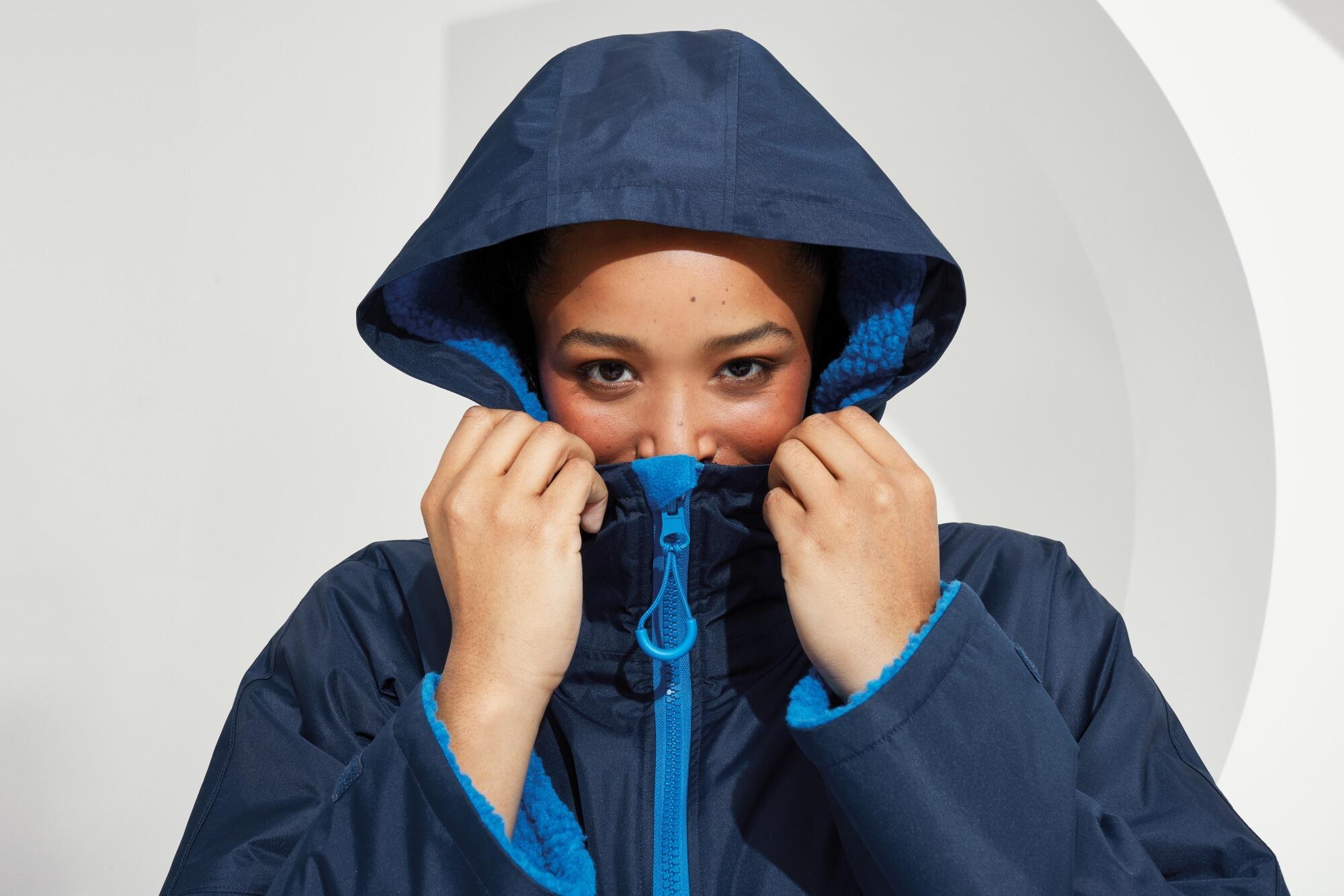 All-seasons waterproof changing robe with a hood, adjustable straps, double zip closure, and multiple deep pockets, featuring a waterproof exterior and cosy sherpa fleece interior.