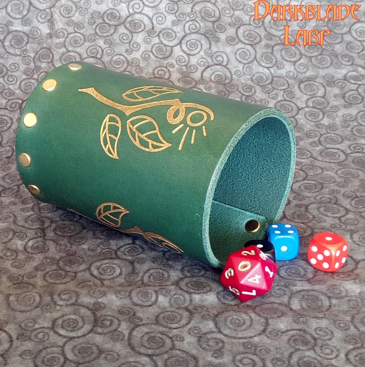 A leather dice cup with an engraved stylised druid symbol