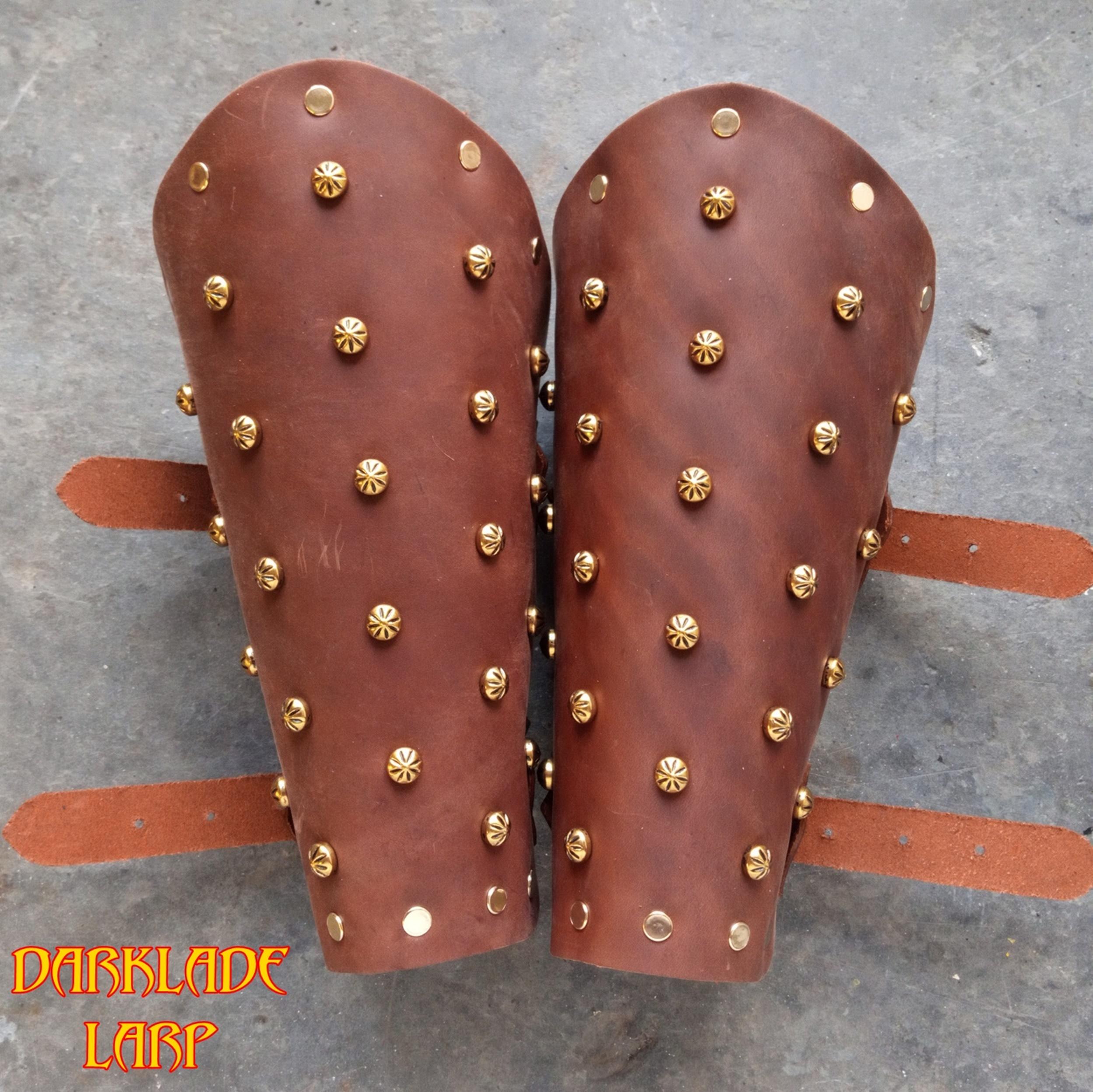 A pair of brown vambraces with onion dome rivet decoration