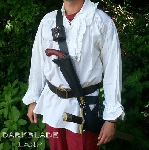 A broad strap crossing the chest with a pistol attached at the front and a part scabbard at the hip