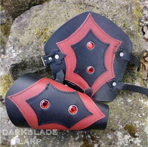 Black leather vambraces with red highlights and red gemstones